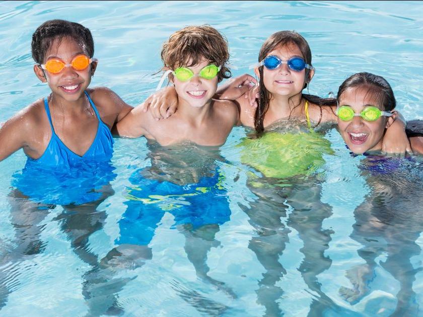 Four kids with goggles in pool
